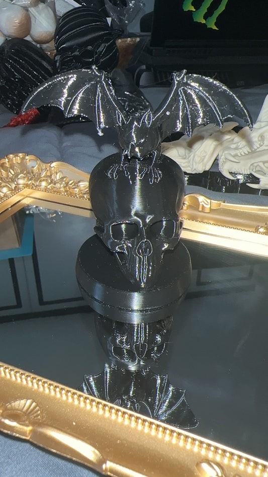 Black 3D printed bat perched on a skull with round display base