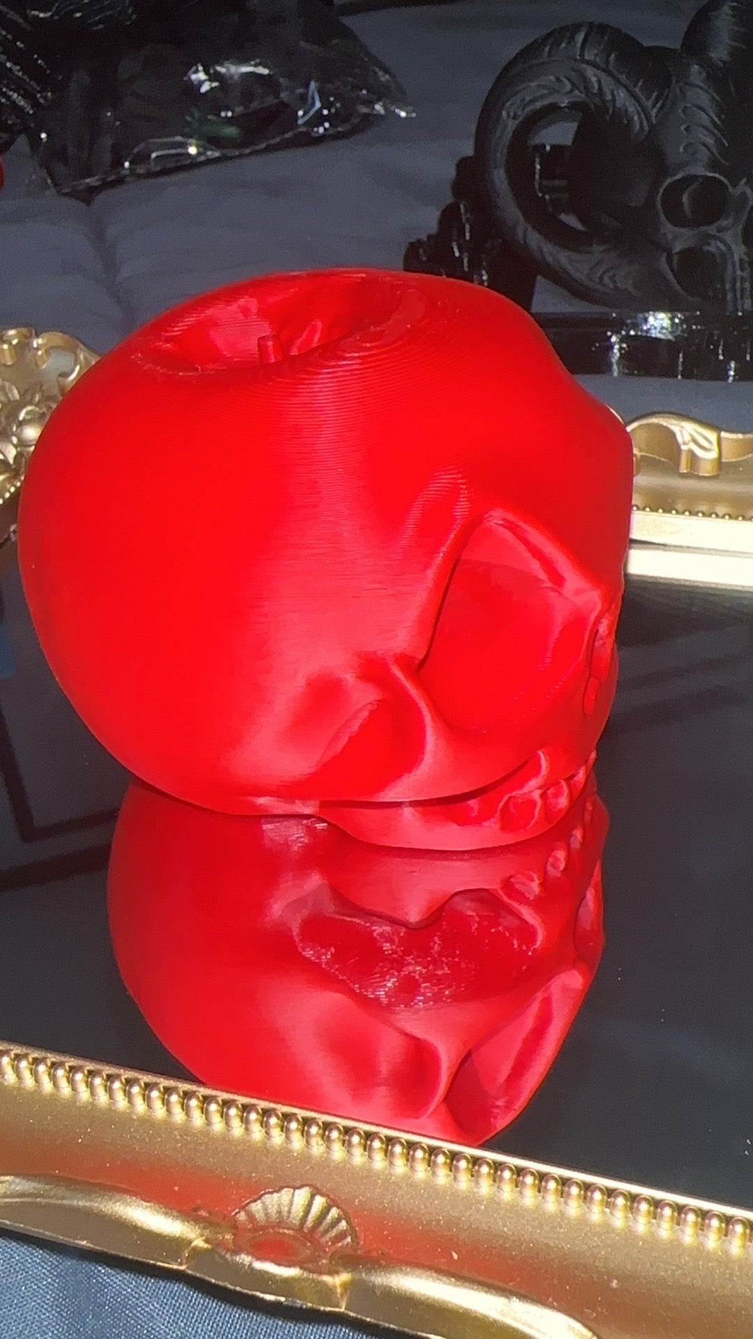 Red 3D printed apple skull viewed from the side